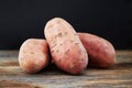 Raw sweet potatoes batata on a rustic wooden table with black background. Close up Royalty Free Stock Photo