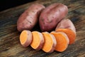 Raw sweet potatoes batatas on a rustic wooden table with black background Royalty Free Stock Photo