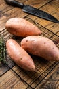 Raw sweet potatoes on kitchen table, fresh batata. Wooden background. Top view Royalty Free Stock Photo