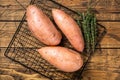 Raw sweet potatoes on kitchen table, fresh batata. Wooden background. Top view Royalty Free Stock Photo