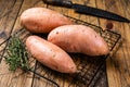 Raw sweet potatoes on kitchen table, fresh batata. Wooden background. Top view Royalty Free Stock Photo