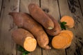 Raw sweet potatoes on rustic wooden background. Royalty Free Stock Photo