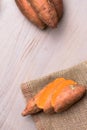 Raw sweet potatoes on wooden background in burlap sack Royalty Free Stock Photo