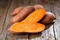 Raw sweet potatoes on wooden background closeup. Royalty Free Stock Photo