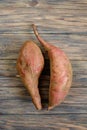 Raw sweet potatoes on wooden background top view. Royalty Free Stock Photo