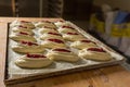 Raw sweet yeast dough on a baking sheet, filling buns jam. Preparation for baking. The concept of chefs and baking Royalty Free Stock Photo