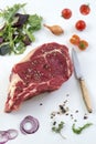 Raw T-bone Steak for grill or BBQ on cutting board with knife over on a white background, top view Royalty Free Stock Photo