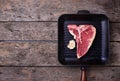 Raw T-bone steak on iron grill pan Royalty Free Stock Photo