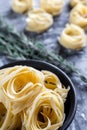 Raw tagliatelle nido on the flour-dusted black wooden background Royalty Free Stock Photo