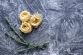 Raw tagliatelle nido on the flour-dusted black wooden background Royalty Free Stock Photo