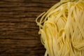 Raw tagliatelle pasta on wooden surface Royalty Free Stock Photo
