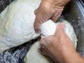 Raw thick dough in the hands of a woman baker. Ready dough for baking in a pan Royalty Free Stock Photo