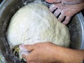 Raw thick dough in the hands of a woman baker. Ready dough for baking in a pan. Test batch. Cook's hands.