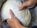 Raw thick dough in the hands of a woman baker. Ready dough for baking in a pan