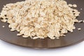 Raw thick-rolled oats on brown dish close-up