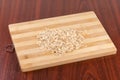 Raw thick-rolled oats on wooden cutting board on table