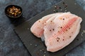 Raw tilapia fish fillet with thyme, pepper an spices ready for cooking. Close up, top view Royalty Free Stock Photo