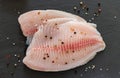 Raw tilapia fish fillet with thyme, pepper an spices ready for cooking. Close up, top view Royalty Free Stock Photo