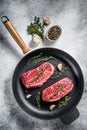 Raw top-blade steak in a pan. Gray background. Top view Royalty Free Stock Photo