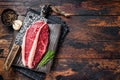 Raw top sirloin cap beef meat steaks on butcher board with meat cleaver. Dark woden background. Top view. Copy space Royalty Free Stock Photo