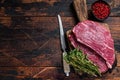 Raw top sirloin cap steak or Picanha steak on wooden board with thyme. Dark wooden background. Top view. Copy space Royalty Free Stock Photo