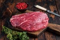 Raw top sirloin cap steak or Picanha steak on wooden board with thyme. Dark wooden background. Top view Royalty Free Stock Photo