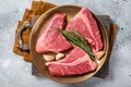 Raw Topside sirloin beef cut on steel plate with spices. Gray background. Top view