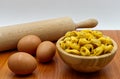 Raw Tortellini in a wooden bowl with rolling pin and eggs. Traditional italian cuisine. Royalty Free Stock Photo