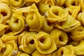 Raw Tortellini in a wooden bowl on wooden table. Traditional italian pasta. Royalty Free Stock Photo