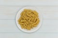 Raw tortiglioni pasta in a white plate Royalty Free Stock Photo