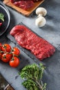 Raw tri tip, bottom sirloin cut steak on black  slate raw organic food , marbled beef over other alternative cuts  with herbs Royalty Free Stock Photo