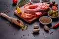 Raw trout red fish steak served with herbs and lemon and olive oil on a dark background Royalty Free Stock Photo