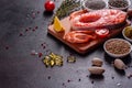 Raw trout red fish steak served with herbs and lemon and olive oil on a dark background Royalty Free Stock Photo
