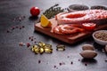 Raw trout red fish steak served with herbs and lemon and olive oil on a dark background Royalty Free Stock Photo