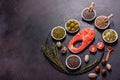 Raw trout red fish steak served with herbs and lemon and olive oil on a dark background Royalty Free Stock Photo