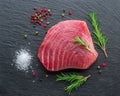 Raw tuna fish steak on natural stone black slate serving plate. Top view Royalty Free Stock Photo