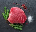 Raw tuna fish steak on natural stone black slate serving plate. Top view Royalty Free Stock Photo