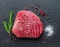 Raw tuna fish steak on natural stone black slate serving plate. Top view Royalty Free Stock Photo