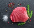 Raw tuna fish steak on natural stone black slate serving plate. Top view Royalty Free Stock Photo