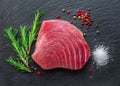 Raw tuna fish steak on natural stone black slate serving plate. Top view Royalty Free Stock Photo