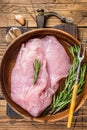 Raw turkey breast fillet, Poultry meat in a wooden plate. wooden background. Top View Royalty Free Stock Photo