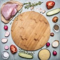 Raw turkey breast with tomato and pepper radish herbs and cucumbers over wooden cutting board on rustic wooden background top view