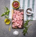 Raw turkey with tomato sauce, pepper, spices, herbs ingredients for stew wooden rustic background top view close up