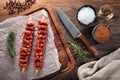Raw Turkish Adana kebab on white cooking paper and wooden cutting table. Dercorated with herbs, spices and chef`s knife Royalty Free Stock Photo