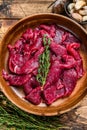 Raw uncooked beef meat sliced in strips with fresh herbs for beef stroganoff. wooden background. Top view Royalty Free Stock Photo