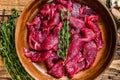 Raw uncooked beef meat sliced in strips with fresh herbs for beef stroganoff. wooden background. Top view Royalty Free Stock Photo