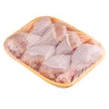 Raw and uncooked chicken drumsticks in a yellow plastic container. Meat of poultry in tray, isolated on white background
