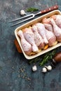 Raw uncooked chicken legs, drumsticks on wooden board, meat with ingredients for cooking Royalty Free Stock Photo