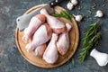 Raw uncooked chicken legs, drumsticks on wooden board, meat with ingredients for cooking Royalty Free Stock Photo