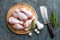 Raw uncooked chicken legs, drumsticks on wooden board, meat with ingredients for cooking Royalty Free Stock Photo